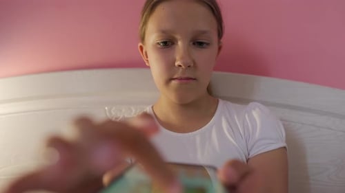 Girl using Device in Bed at Home