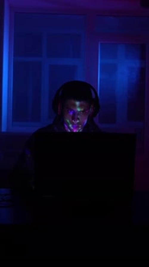 Focused Young Adult Gamer in Dark Room