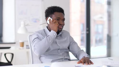 Man in Office Talking on Mobile Phone