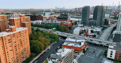 Flight above the buildings tops and busy roads. New York bridges over Hudson at backdrop.