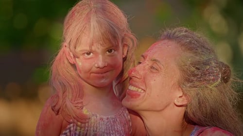 Mother and Daughter in Colorful Paint at Holi Festival Happy and Contented Looking at Camera and