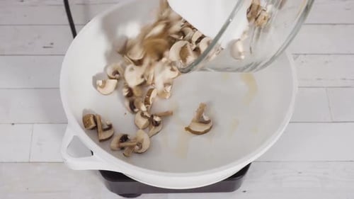 Sauteed Organic Baby Bella Mushrooms in a White Frying Pan