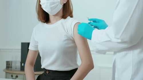 Adult Woman Receives Arm Injection in Clinic