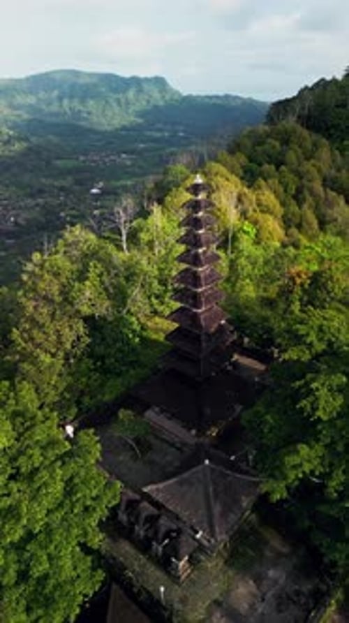 Vidéo filmée par Drone d'un sanctuaire balinais traditionnel s'élevant au-dessus d'une vallée de la forêt tropicale