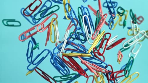 Colorful Paperclips Floating Against Light Blue Background