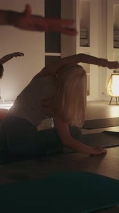 Women Practice Yoga in Softly Lit Studio