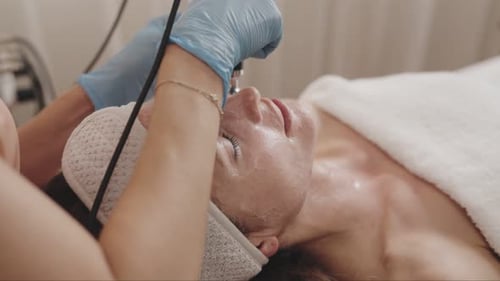 Woman Receives Facial Treatment in Spa Setting