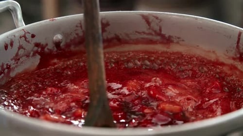 Strawberry Jam Cooking with Wooden Spoon in Pot
