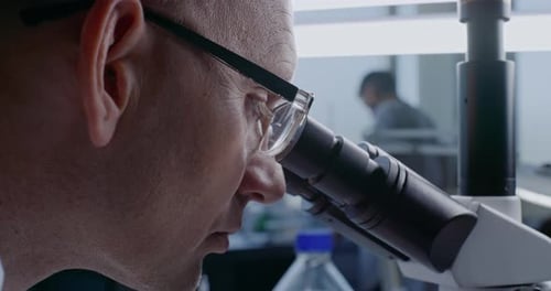 Scientist Looking Through Microscope in Lab Close Up