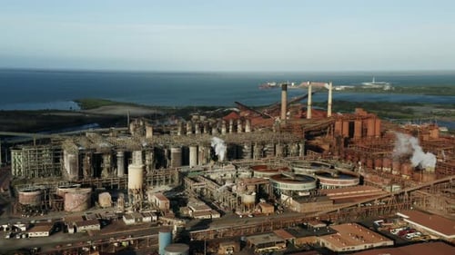 Drone shot of industrial Factory producing energy in front of ocean