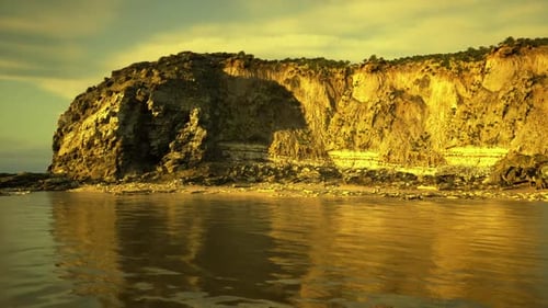 Golden Hour Coastal Cliff with Reflecting Water