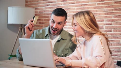 A Young Caucasian Couple Using a Laptop to Place an Online Order and Pay for It with Their Credit