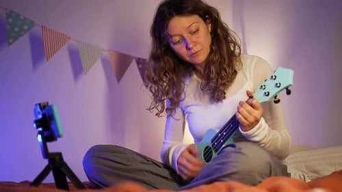 Woman Plays Ukulele at Home for Video Recording