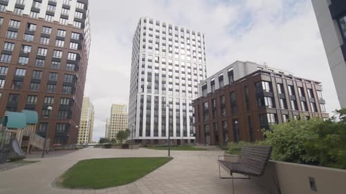 Area with Playground Bench and Trees Surrounded By Tall Buildings