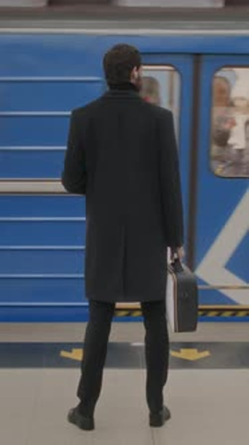 Man Standing against Railroad with Subway Train Passing by