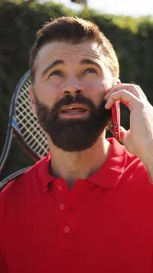 Man Talking on Phone with Tennis Racket