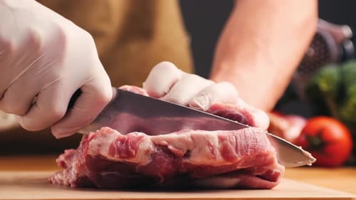 Person Cutting Red Meat with a Knife