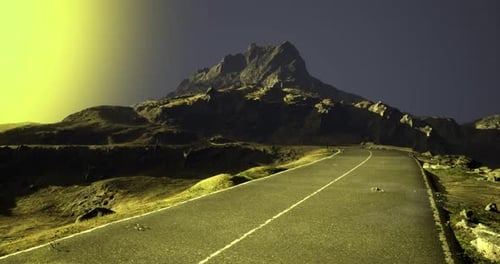 Road Winding Through Mountainous Terrain Under a Vibrant Sunset Sky