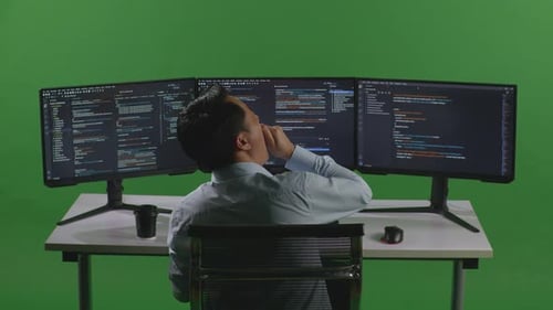 Tired Man Yawning Before Sleeping While Write Code With Multiple Computer Screens In Green Screen