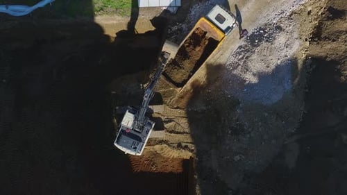 Excavator Loading Soil into a Dump Truck, Aerial View