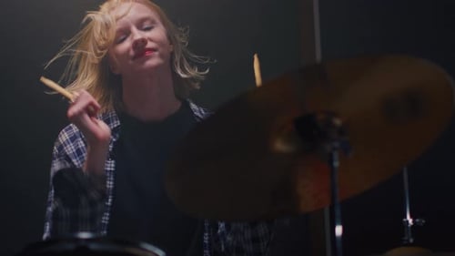 Girl Blonde Rock is Playing Drums on Concert Stage Woman Bangs on a Drum Kit Female Musician Bangs