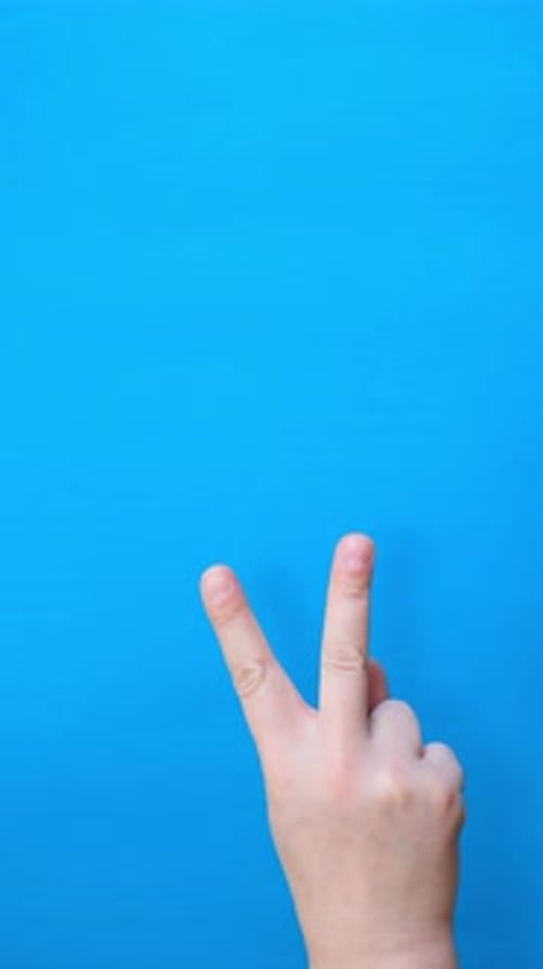 Child's Hand Displays Number Two on Blue