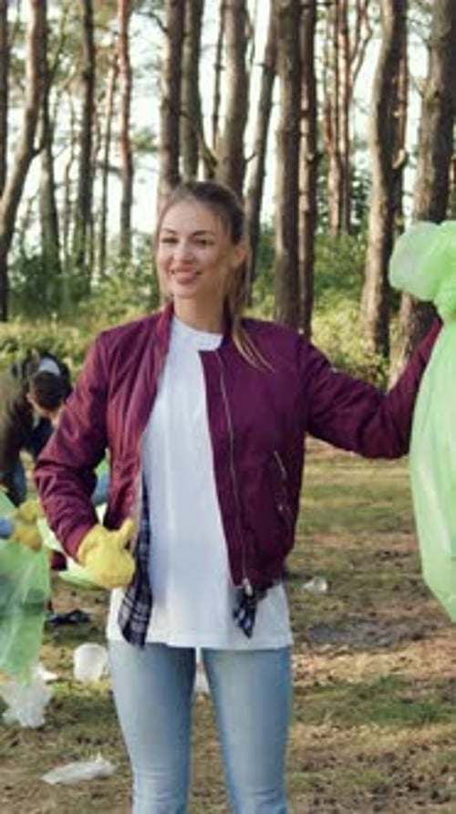Concepto de protección del medio ambiente en el que una niña adorable y alegre con una bolsa de plástico llena de basura