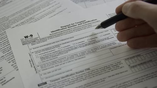 Personne remplissant un formulaire W-9. Demande de numéro d'identification fiscale et de certification.
Personne