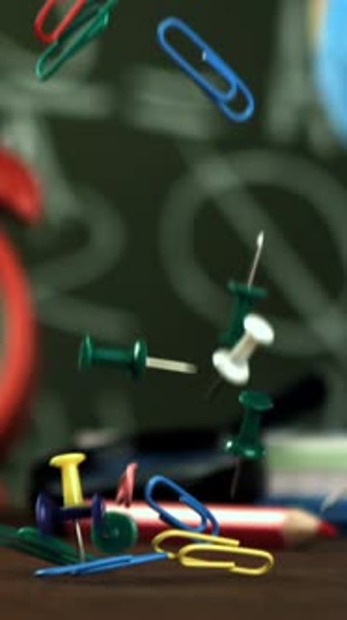 Multicolored Paper Clips Fall on the School Desk Filmed on a Highspeed Camera at 1000 Fps