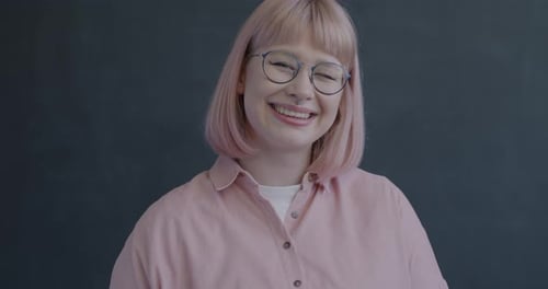 Smiling Woman with Pink Hair Gives Thumbs Up