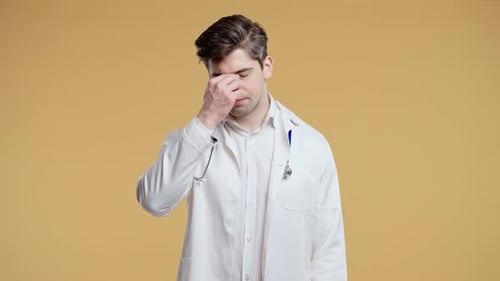 Tired Doctor Rubbing Forehead in Studio