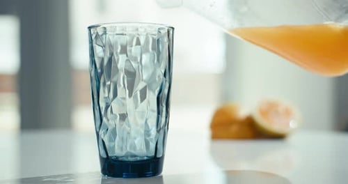 Orange Juice Being Poured into Glass
