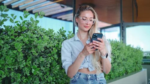 Young Woman Using Smartphone in Urban Setting