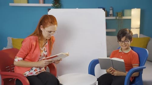 Woman and Child Reading Books Indoors