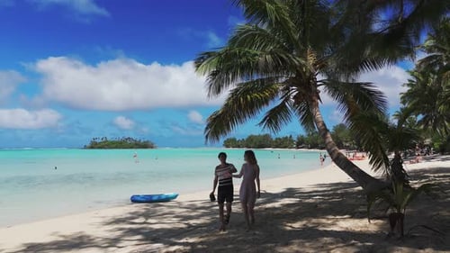 Newlywed Couple Walking on Sandy Beach Beneath Palm Trees on Tropical Paradise Island