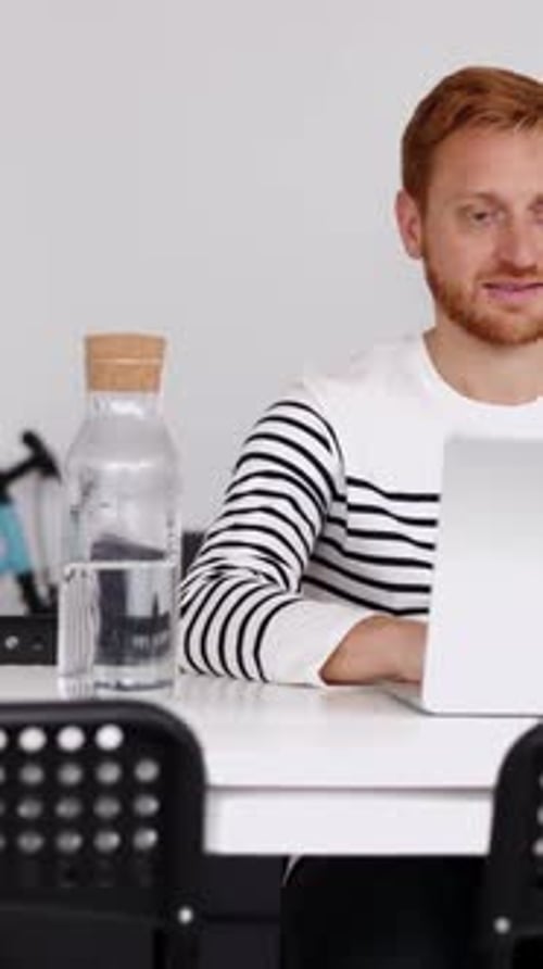 Young Student Man Working on Laptop Computer Sitting on Table at Home