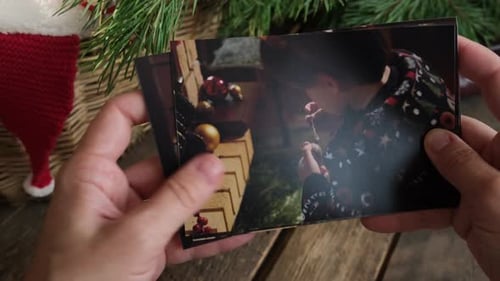 Navegar con las manos a través de imágenes navideñas impresas para un álbum familiar