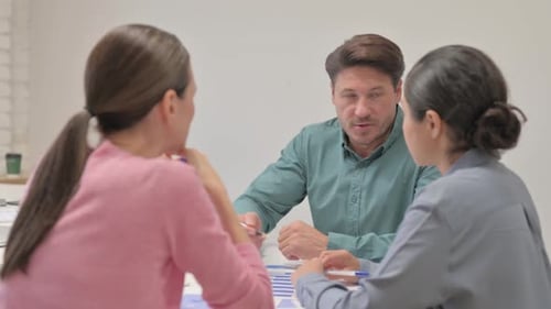 Young Man Discussing with Colleagues in Office