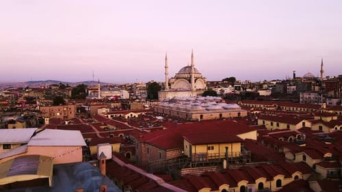 Forward drone shot of Nuru Osmaniye Mosque with view of roofs of buildings and cityscape at backgrou