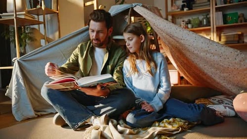 Dad and Daughter Reading Book in Cozy Indoor Tent