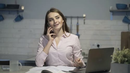 Woman works on laptop at kitchen counter