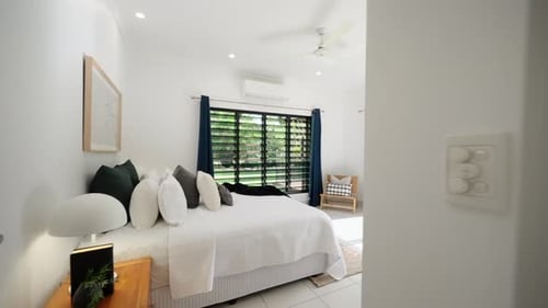 Push in past door frame to reveal stunning master bedroom with sliding door access to tropical backy