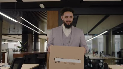 Um novo trabalhador acaba de chegar ao escritório carregando pertences pessoais em uma caixa