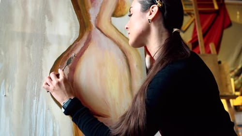 Beautiful woman painting with watercolors at an art gallery workshop