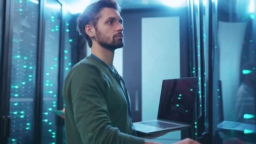 Man Working With Laptop in Data Server Room