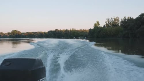 Shot from back of a boat showin the motor and the wake in the water