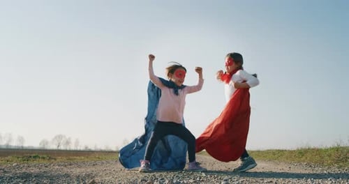Energetic Girls Play Superhero in Rural Setting