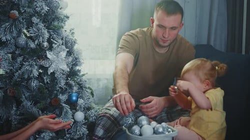 Family Decorating Christmas Tree Together at Home