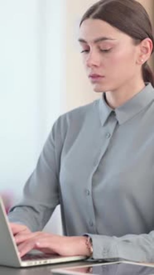 Young Latin Woman Working on Laptop in Office, vertical video