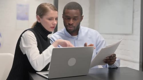 Colleagues Collaborating on a Laptop in Office
